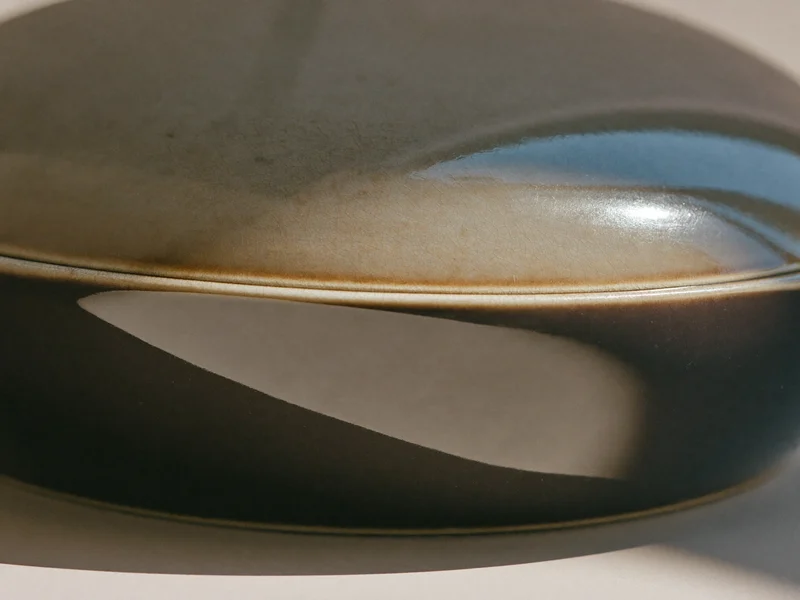 Dettaglio macro dello smalto ceramico con sottile craquelé e bordo del piatto